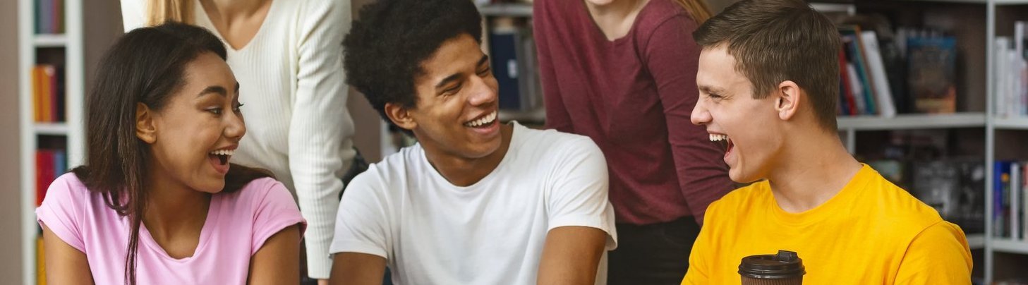 Multinationale Studentengruppe, die an einem Projekt in der Bibliothek arbeitet. Es wird angeregt diskutiert.